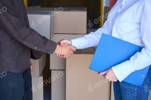 Preview: Lady with blue folder shakes hand with man