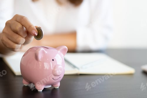 Preview: Close-up woman putting coin in piggy bank. Money saving concept.