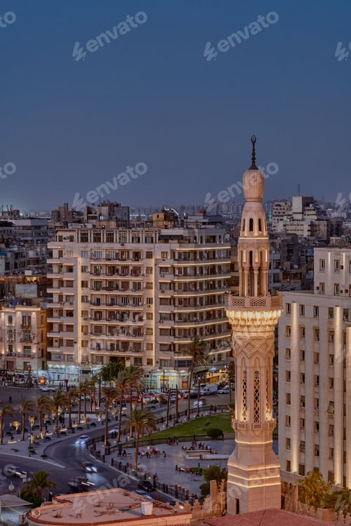 Preview: Aerial view of Tahrir Square in Cairo at night, featuring a brightly-lit Minaret of a mosque.