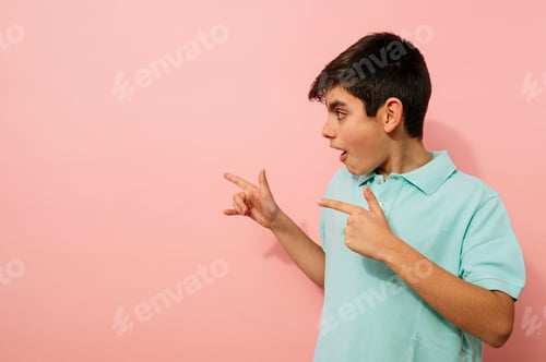 Preview: Young guy pointing aside in studio.
