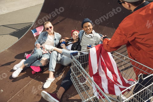 Preview: Teenagers Having Fun and Lying With American Flag in Skateboard Park, Hipster Style Concept
