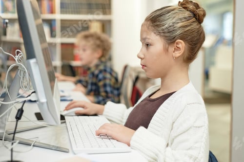 Preview: Serious Schoolgirl using Computer in Library