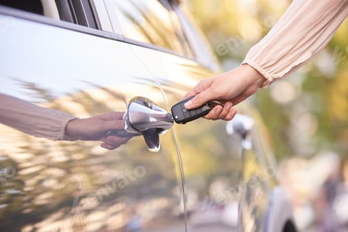 Preview: Closeup of hand unlocking car door with remote key for modern vehicle access