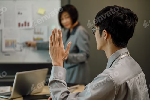 Preview: Side view of Asian male worker raising hand to asking question on a seminar