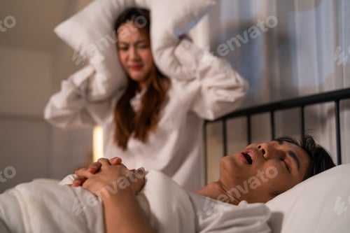Preview: Asian woman feel frustrated from husband snoring while sleep at night.