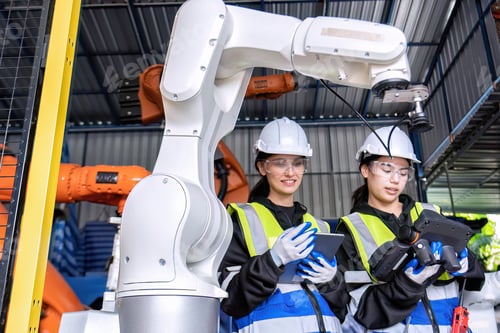 Preview: Women engineer team together at work in modern advanced robot welding machine sell service factory