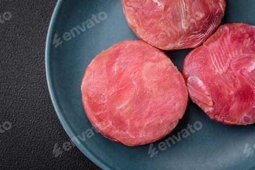 Preview: Round shape steaks of raw juicy tuna with salt and spices