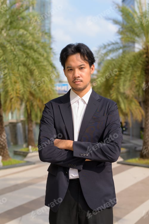Preview: Portrait of Asian businessman outdoors in the city