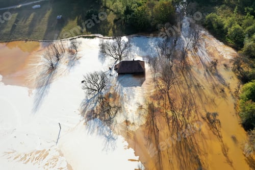 Preview: Aerial view of sinking village house in the middle of toxic mine decanting lake