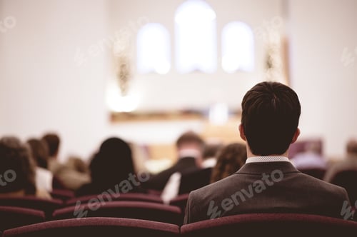 Preview: Male wearing a suit and other people sitting in a church