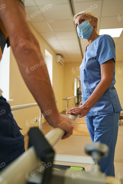 Preview: Female physiotherapist assists mature patient in recovery in rehab center