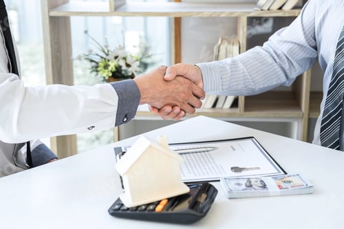 Preview: Broker and client shaking hands after signing contract approved application form