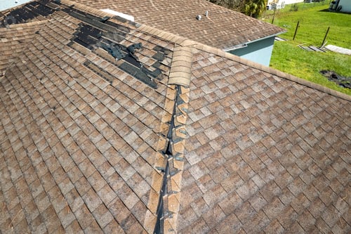 Preview: Damaged house roof with missing shingles after hurricane Ian in Florida.