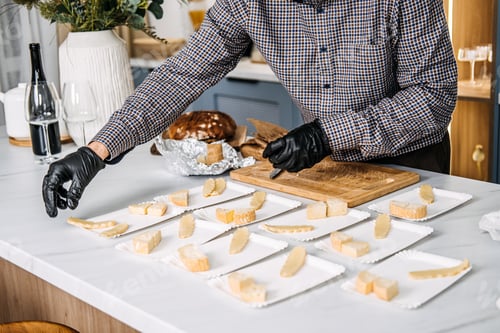 Preview: Catering Professional Arranging Cheese Plates for Service. Professional catering expert in black