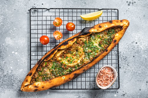 Preview: Turkish pide, traditional pie with beef meat and vegetables. White background. Top view