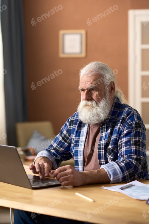 Preview: Senior Man Using Laptop in Home Office