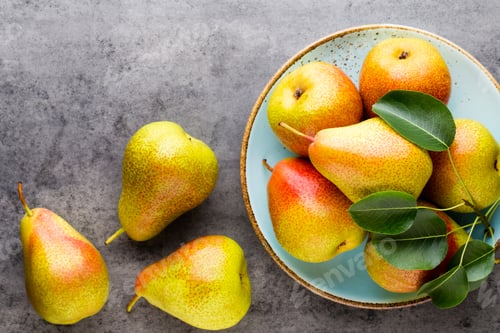 Preview: Fresh bio pear with leaves on the plate. Gray stone table.
