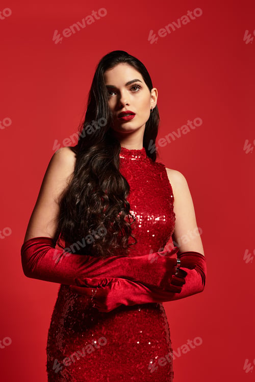 Preview: Elegant young woman radiates confidence in striking red attire with dazzling makeup