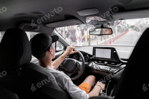 Preview: A young guy driving a car.
