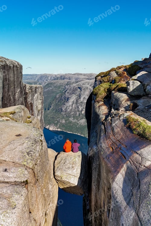 Preview: Adventurers Sitting on Kjeragbolten Overlooking Norway's Spectacular Fjords