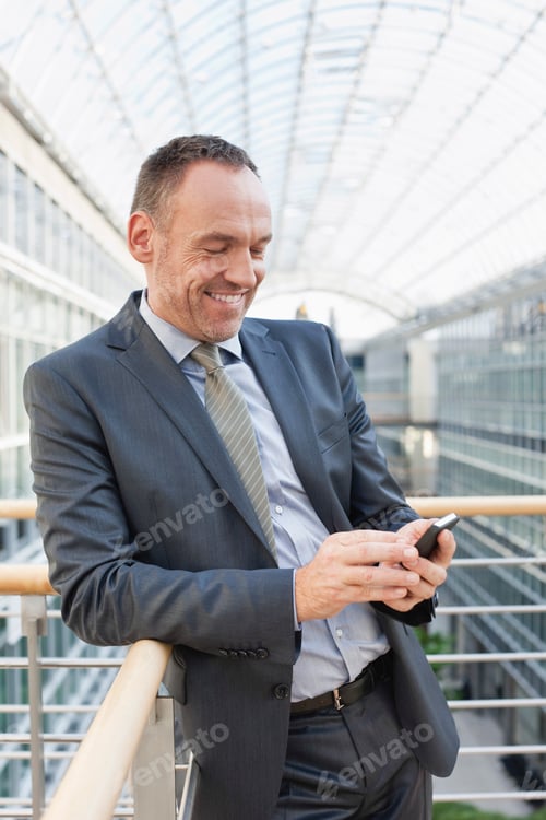 Visualização: Alemanha, Leipzig, empresário usando telefone celular, sorrindo