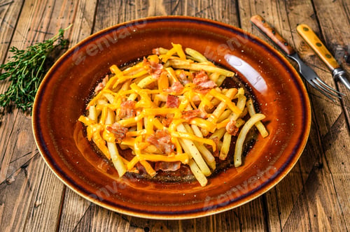 Preview: French fries with melted cheddar cheese and bacon served in a rustic plate