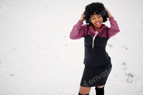 Preview: Curly hair african american woman posed at winter day. Afro model girl against snow.