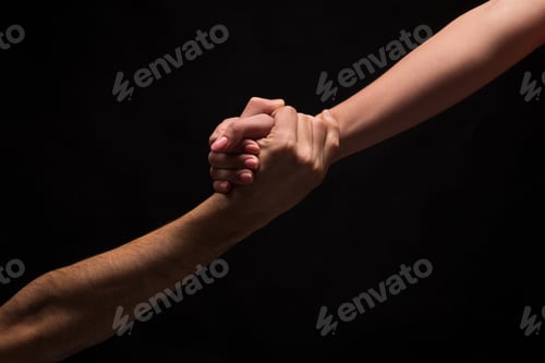 Preview: Hands of man and woman in love, isolated on black