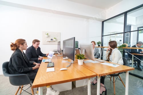 Preview: Team meeting in a modern office space with individuals discussing project ideas