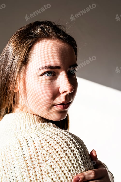 Preview: Portrait of a beautiful young woman with a shadow pattern on the face and body