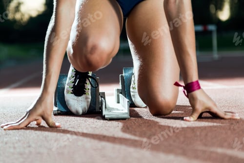 Preview: Young female athlete launching off the start line in a race.