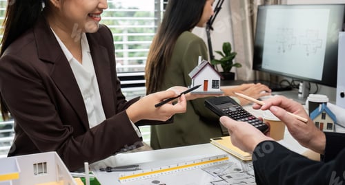 Preview: Business Team Discussing Real Estate Project with House Model and Blueprints in Modern Office