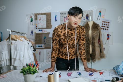 Preview: Portrait of Happy Asian young male tailor with measuring tape on neck.