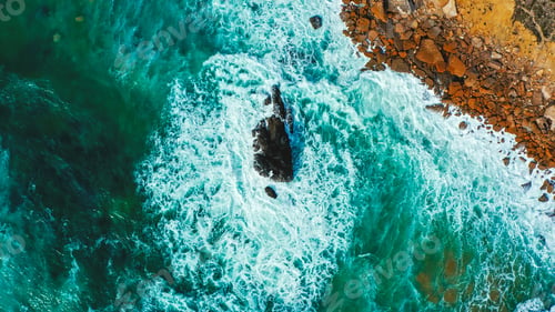 Preview: Drone view over sea water surface the rocky shore. Top view over rolling ocean waves.