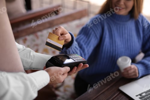 Preview: Woman with credit card using payment terminal at restaurant, closeup
