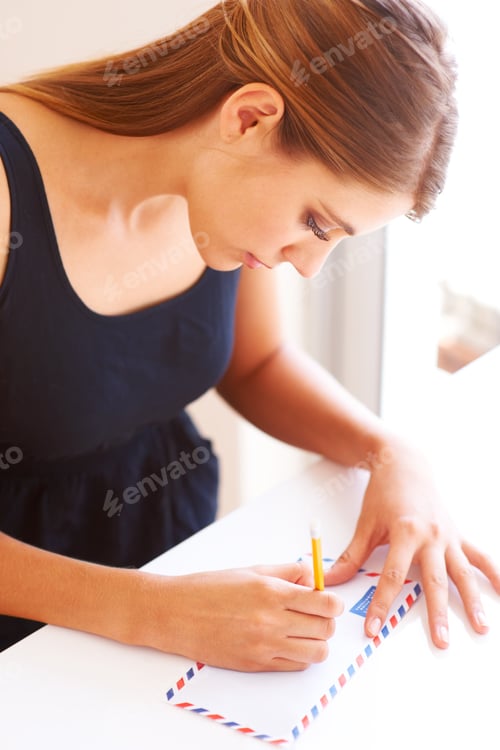 Preview: Writing to her penpal. Cropped view of a woman writing a letter.