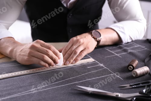 Preview: Tailor working at table in atelier, closeup