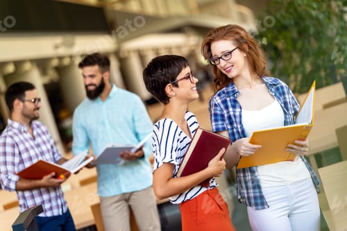 Preview: Happy university students studying with books in library. Group of multiracial people in college