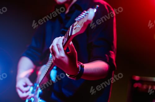 Preview: man playing guitar on a stage musical concert close-up view.guitarist plays.