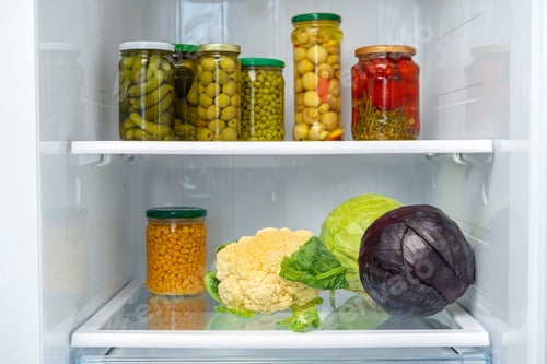 Preview: Glass jars of canned products on a fridge shelf