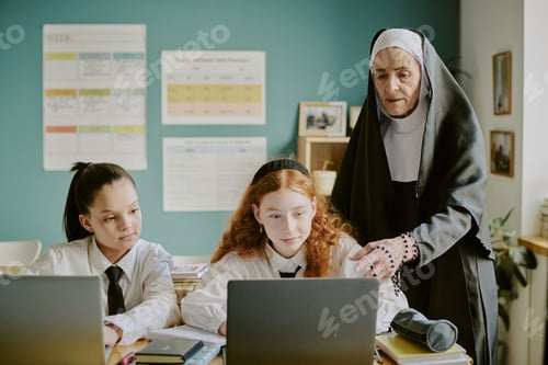 Preview: Educator Guiding Students Working on Laptops