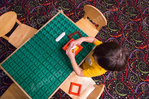Preview: Overhead of Boy Playing With His Toys at Table