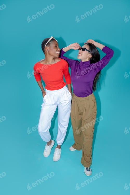 Preview: Two women pose on blue studio background