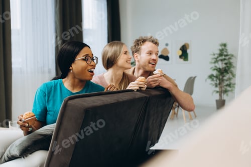 Preview: Diverse friends enjoying snacks watching entertainment together