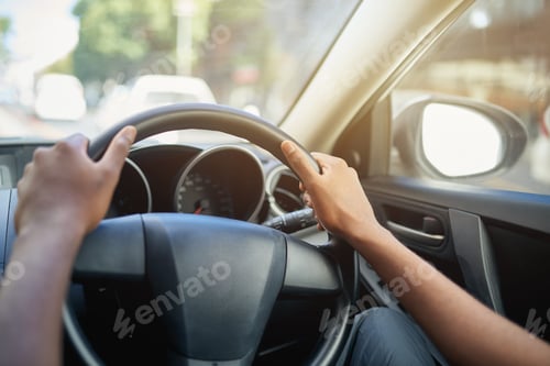 Preview: Cropped shot of a mans hands at the 10 and 2 position on a steering wheel of a car