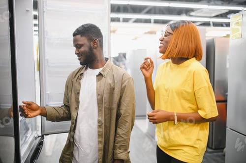 Preview: Young african american man and woman are choosing a fridge in an appliance store.