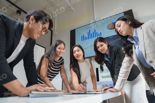 Preview: Business team analyzing charts on a large screen in modern office