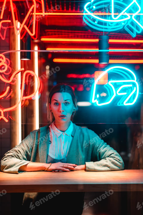 Preview: Beautiful girl in a window cafe and looks at the camera