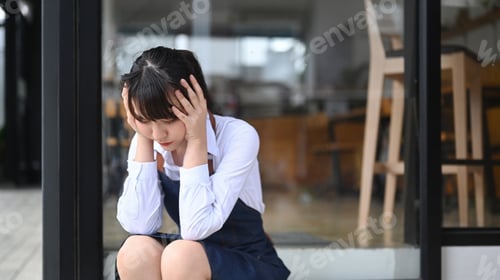 Preview: Young woman coffee shop business owner stressed because of economic conditions.