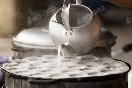 Preview: Pouring coconut milk into a stove preparing for Thai sweetmeat or Coconut-rice pancakes (Kanom Krok)